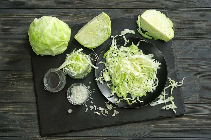 Composition with cut cabbage on wooden table