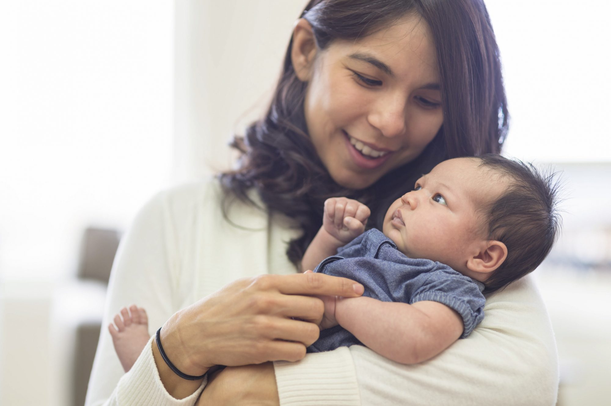 Mother holding baby daughter at home